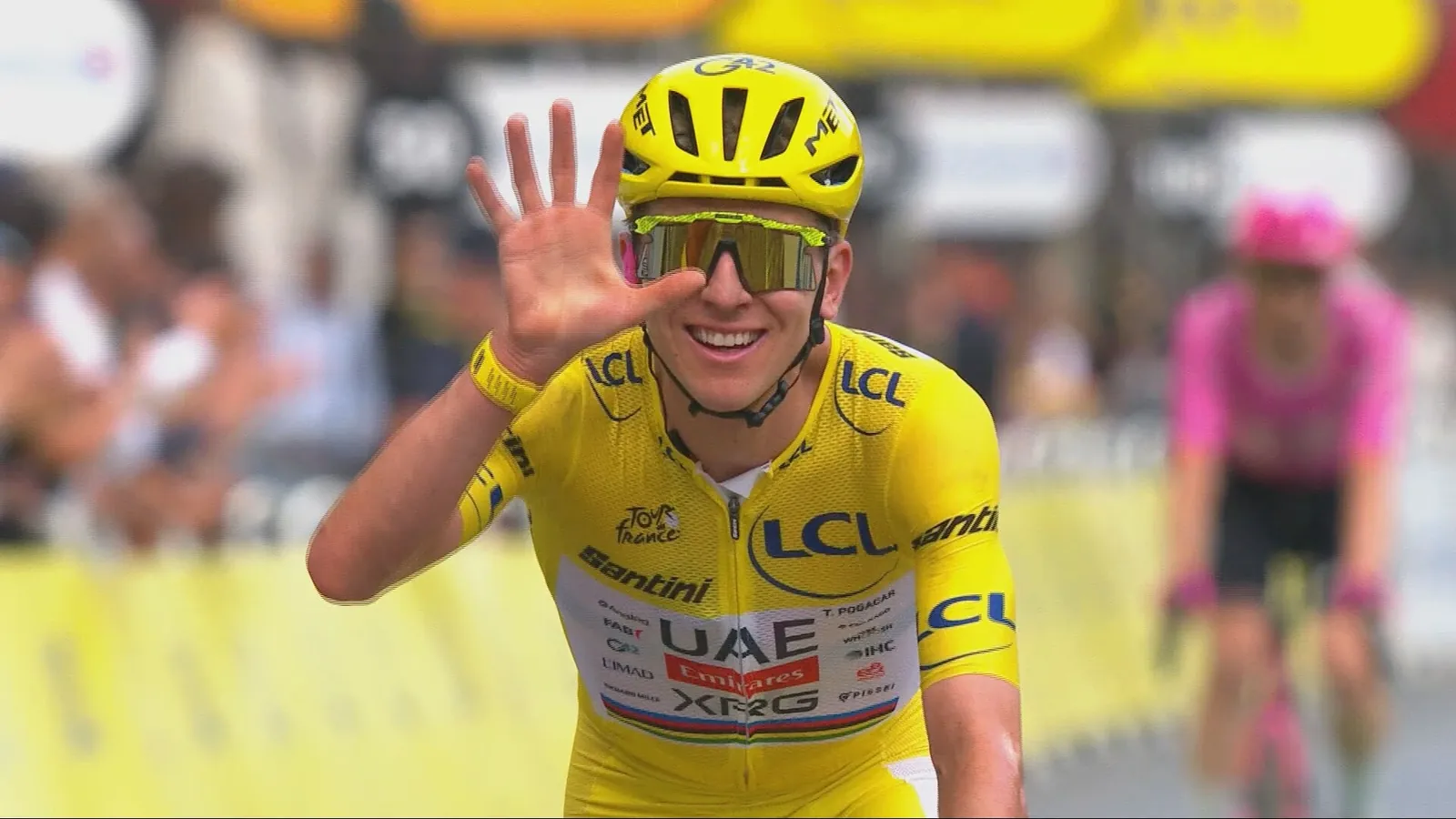 Tadej Pogacar steekt vijf vingers in de lucht op de streep: hij wint zijn vijfde Tour de France.