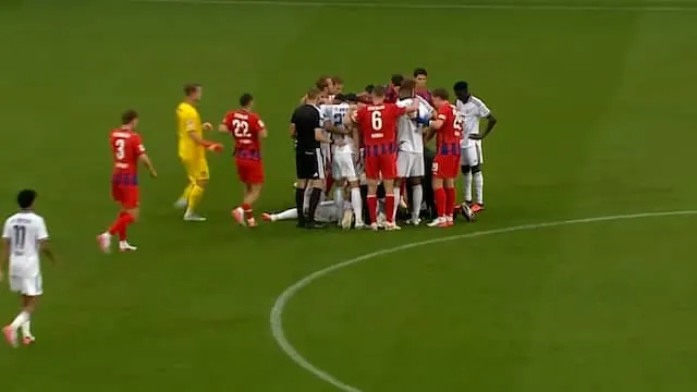 Bayern-spelers omringen Musiala als hij opnieuw naar de grond gaat