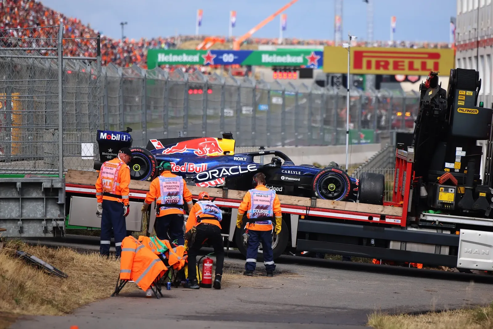 Marshals ruimen de schade op na de crash van Max Verstappen in de eerste ronde op het het circuit van Zandvoort.Foto Formula 1 via Getty Images